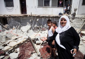 Palestinians look at the rubble of a store following demolished their sheds by Israeli bulldozers, in Ras al-Amud in Jerusalem